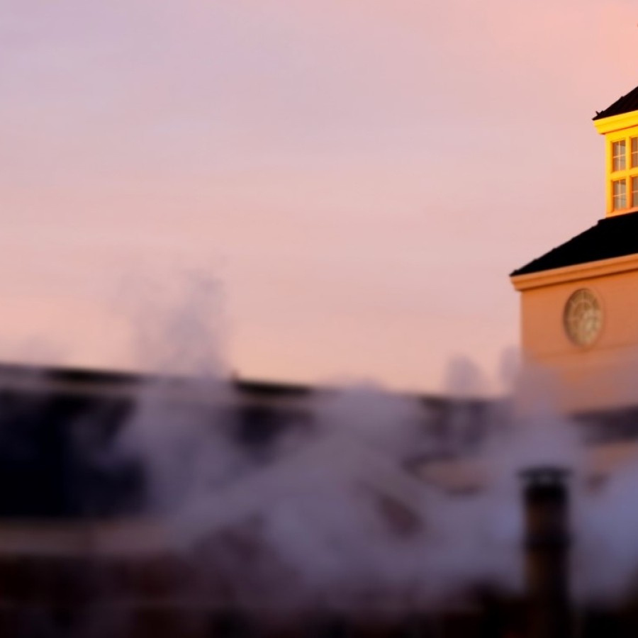 A clock tower with smoke coming out of it