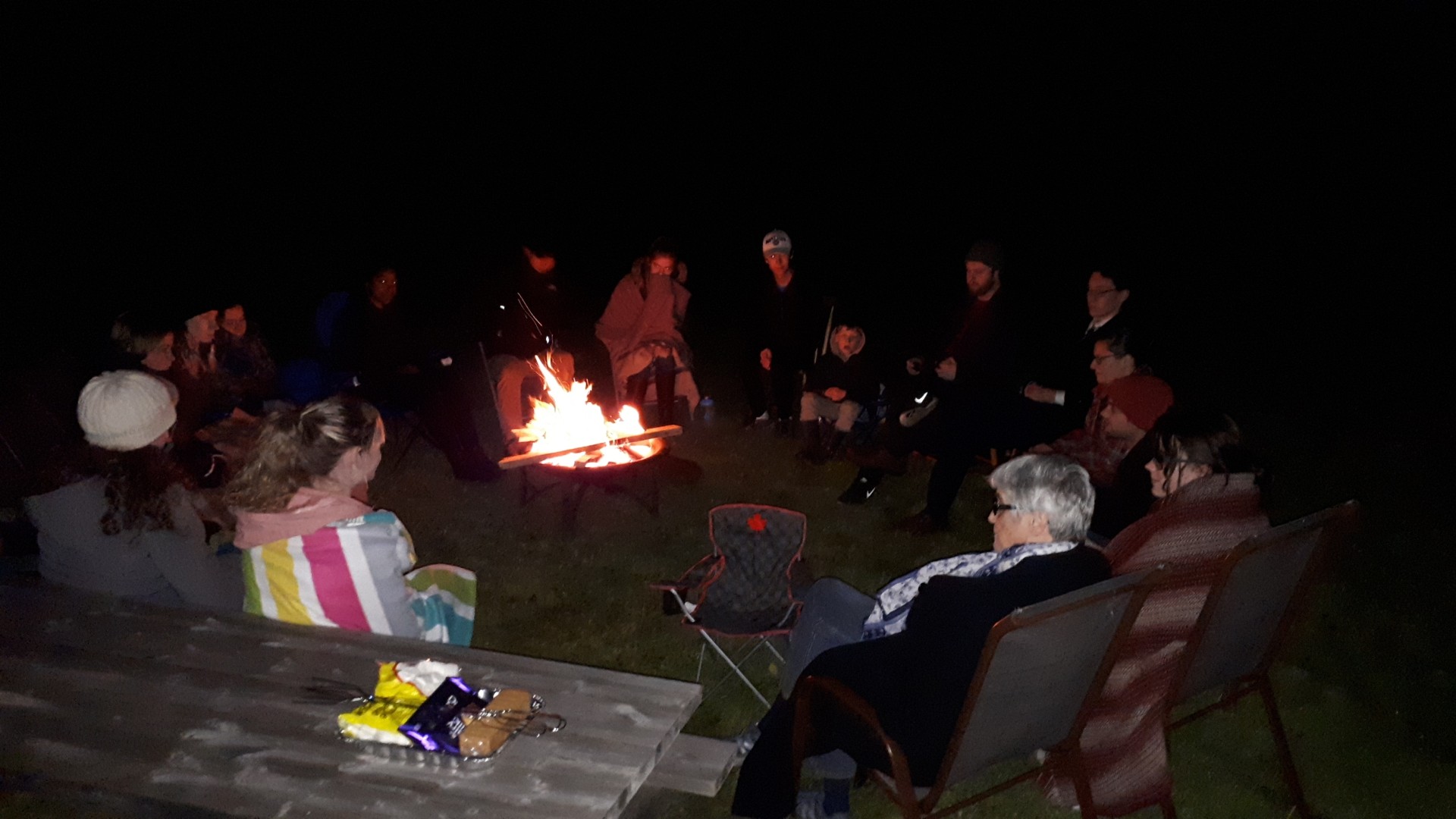 A group of people sitting around a bonfire