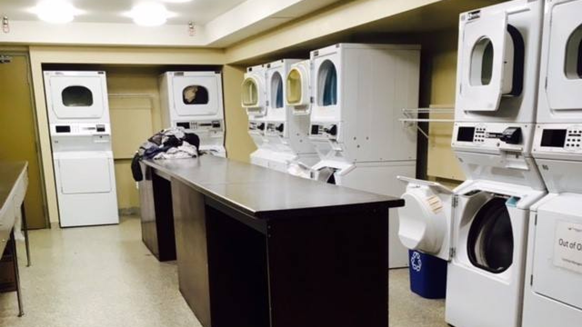 Laundry room with washers and dryers lined up and a counter in the center of the room.
