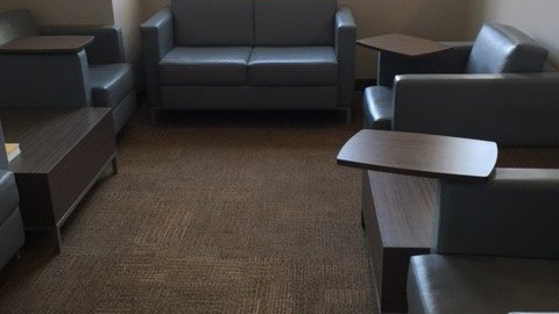 Study lounge with sofa chairs and small tables attached 