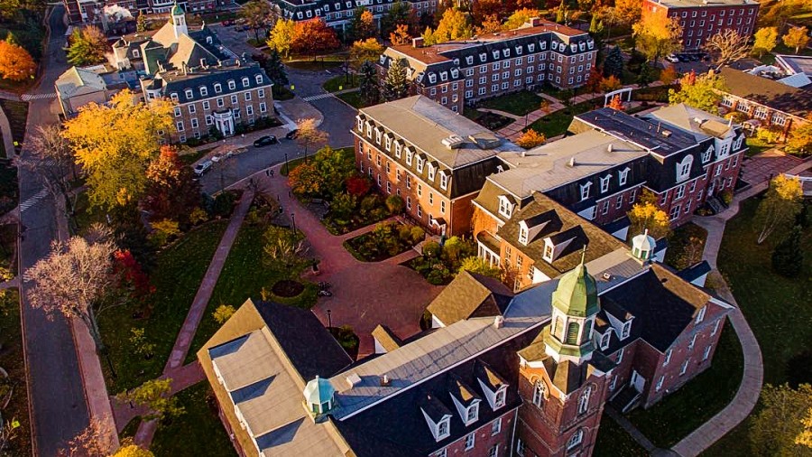 Aerial view of Xavier Hall, along with other buildings in the distance on a fall day with colorful trees.