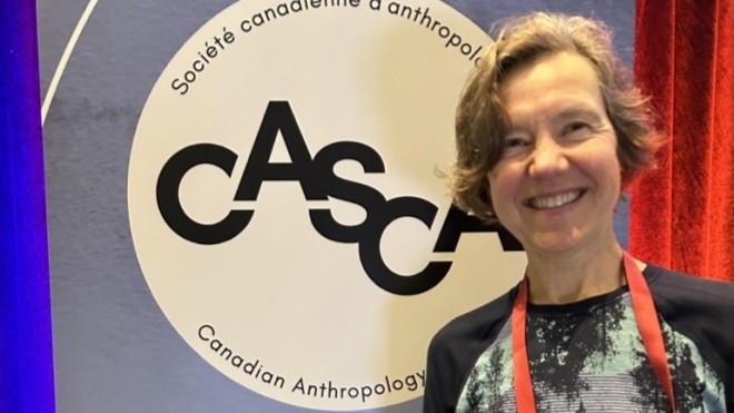 Dr. Susan Vincent standing in front of a CASCA banner