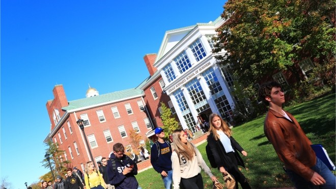 Students Walking outside on a sunny day, leaving the Gerald Schwartz School of Business