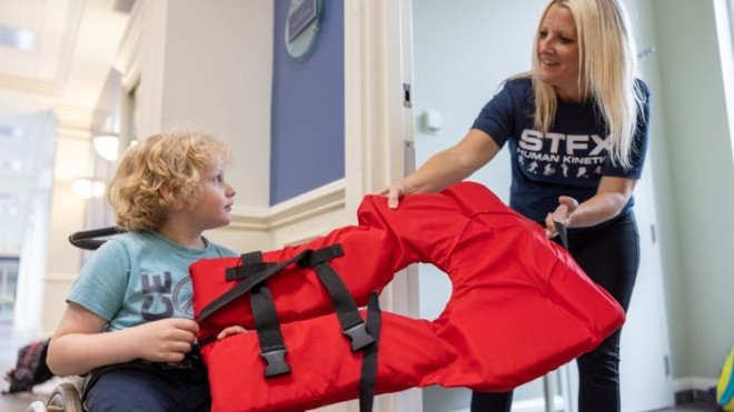 A child and a woman holding a life jacket
