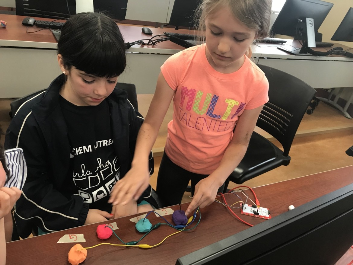 Two young girls working on a project together