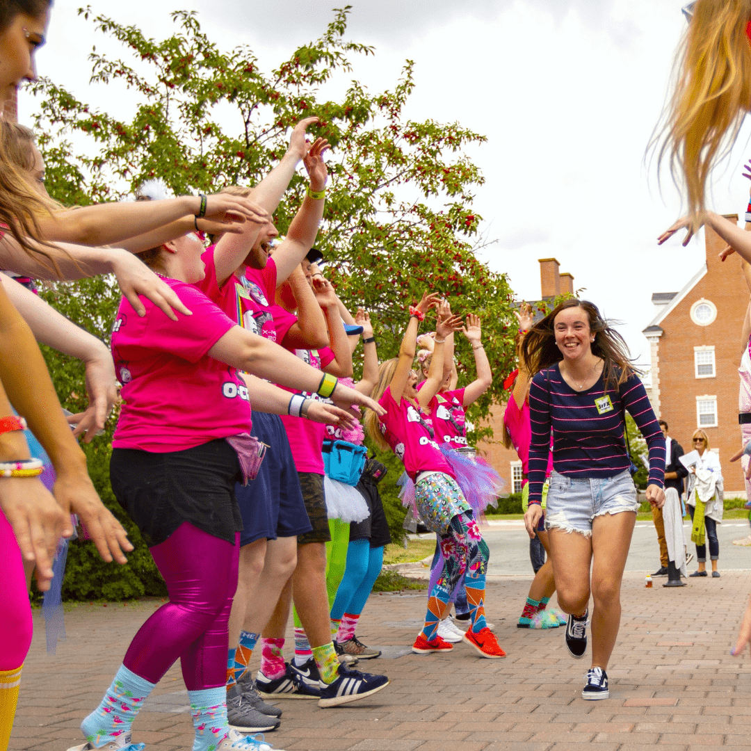 Student running through welcome tunnel during orientation