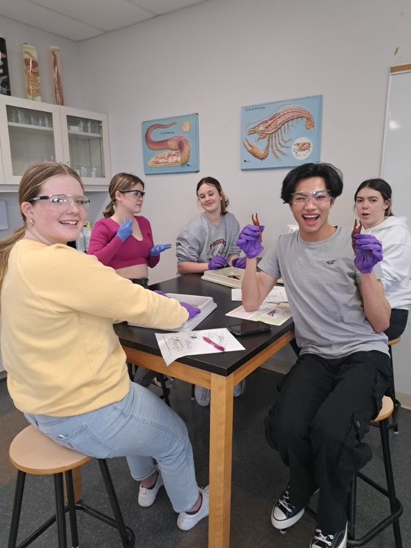 Grade 10 Students Smiling at the Camera While They are in the Lab