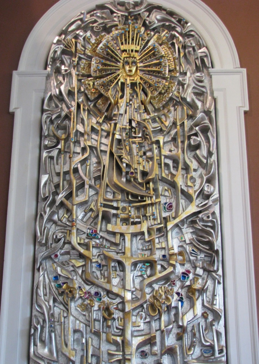 A carved gold-painted panel featuring religious symbolism.