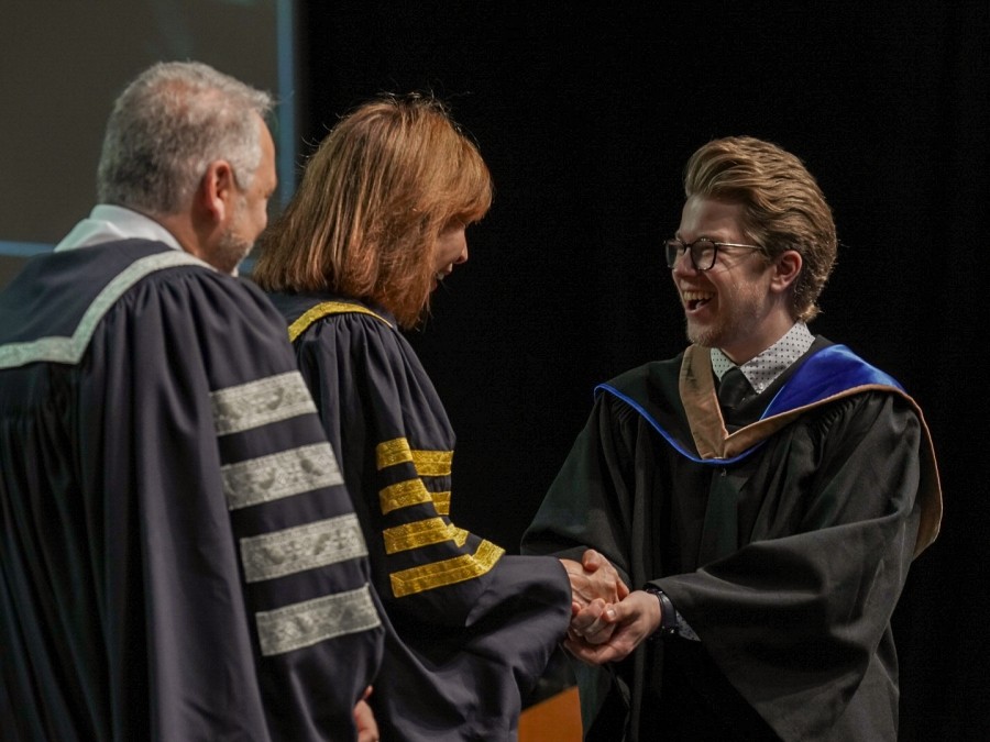 A Class of 2025 student shakes hands with Chancellor, Dr. Mila Mulroney