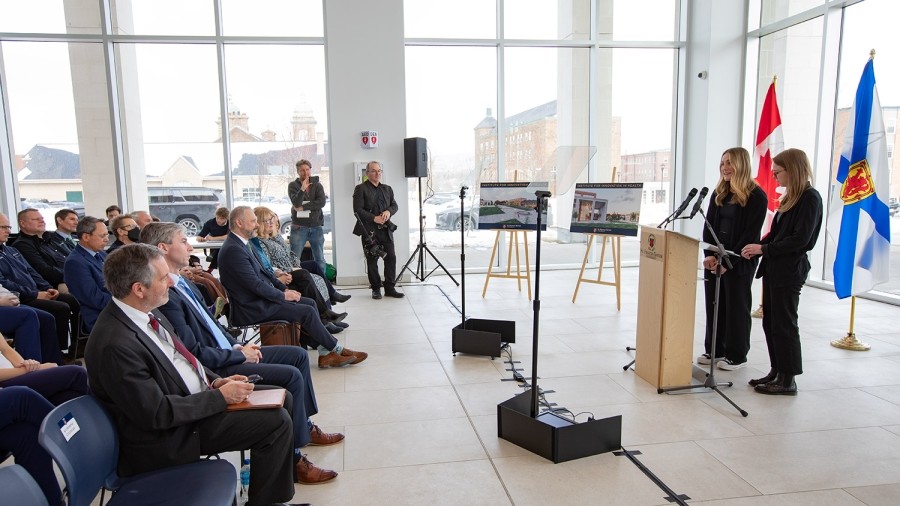 Two people at a podium with seated people watching