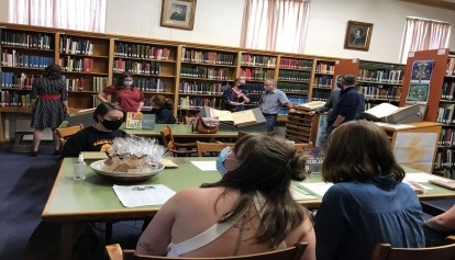 Mask wearing people sitting in the library