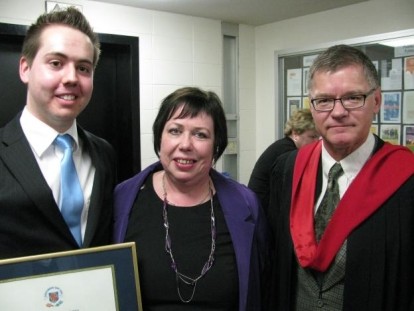 Alex Warshick smiling in the left, showing his diploma. In the center, a woman smiling. In the right side, a man