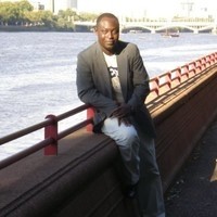 Person leaning on bridge in front of water