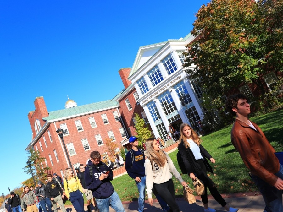 Students Walking outside on a sunny day, leaving the Gerald Schwartz School of Business
